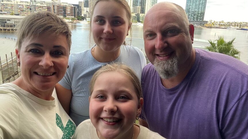 A selfie photo of four, including male and female parent and two daughters 