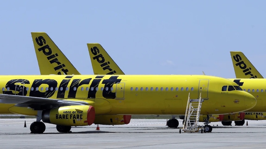 A yellow airplane on a runway with the words spirit on it