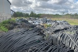 Plastic waste mounds outside a factory.