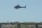 A police helicopter searches for missing anglers south of Newcastle on May 11, 2010.
