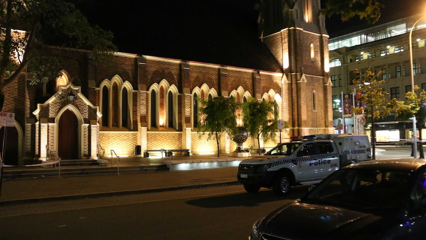 A police vehicle stands outside a large church.