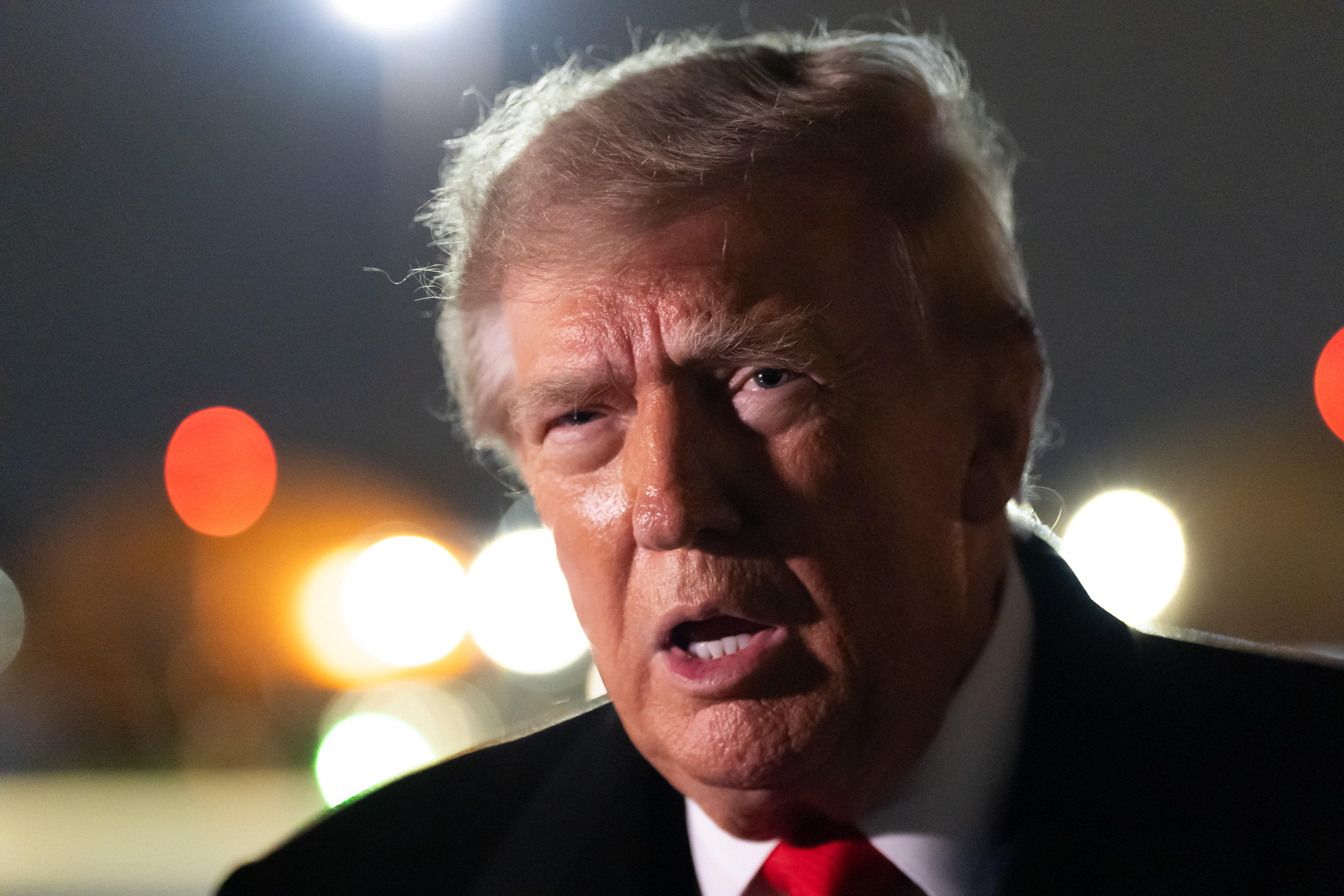 A close-up shot of Donald Trump's face as he speaks, on a blurred background.