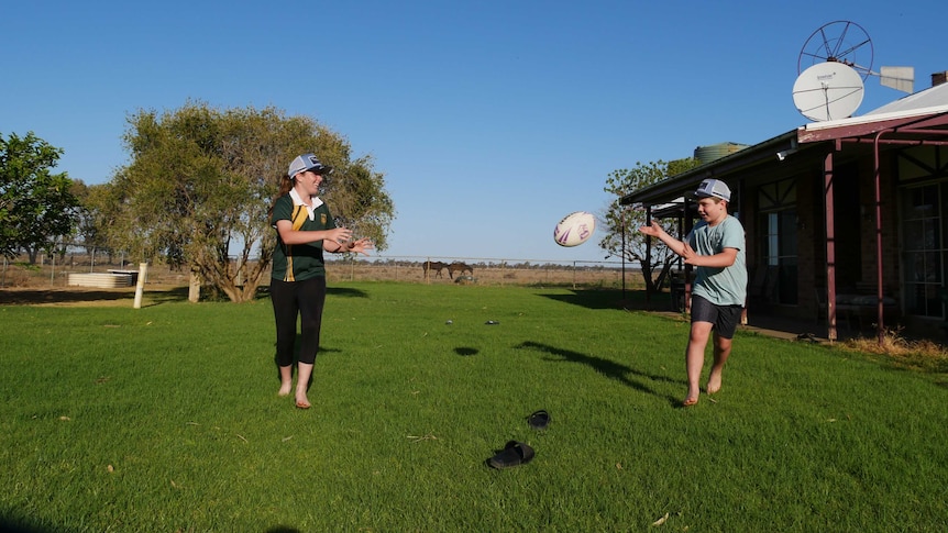 Lincon runs to the camera passing a football mid air to his sister