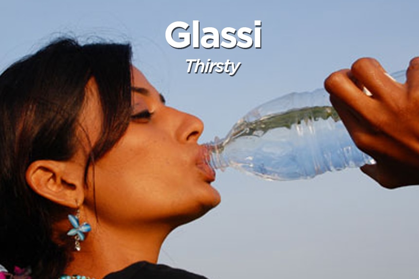 A woman drinks from a bottle of water.