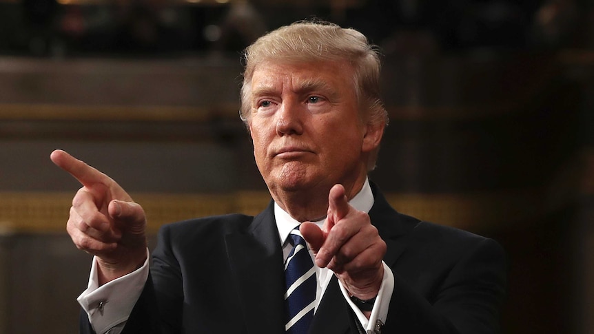 US President Donald Trump points with both hands.