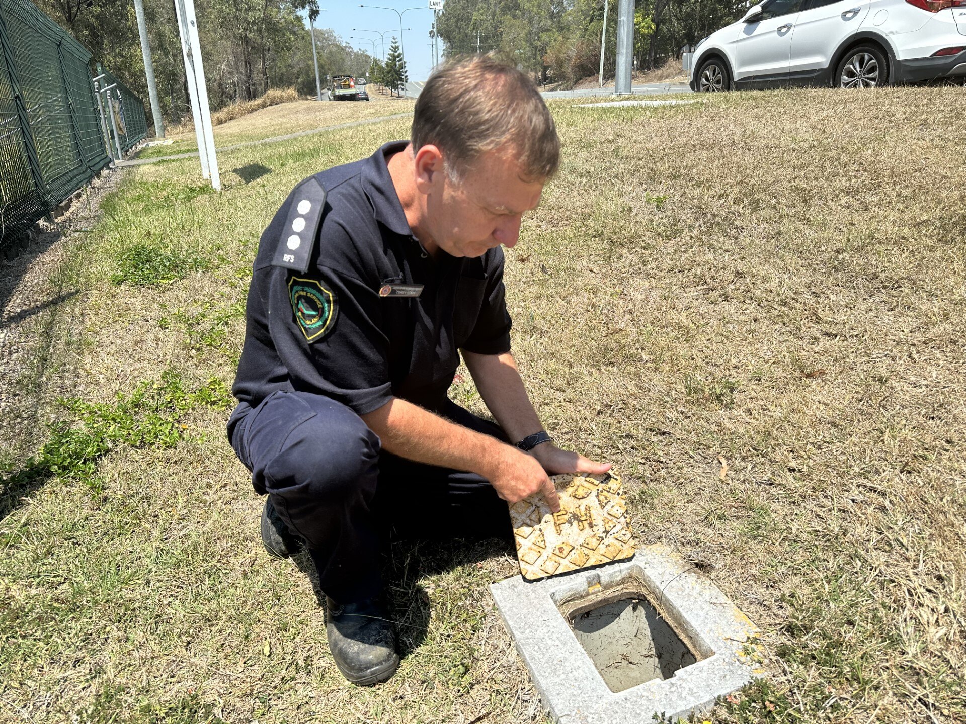 Man kneeling and pointing at Fire Hydrant Cover