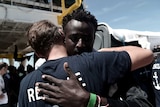A migrant hugs a crew member from the Aquarius rescue ship