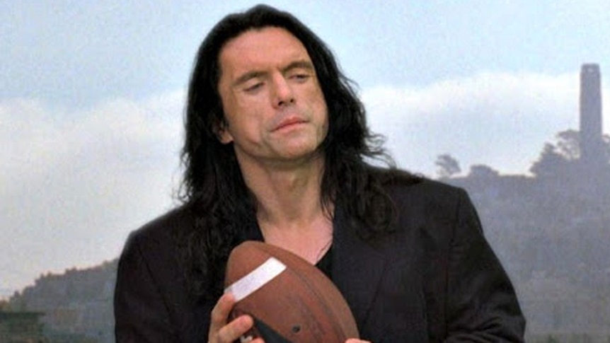 Tommy Wiseau holds a football in a scene from The Room