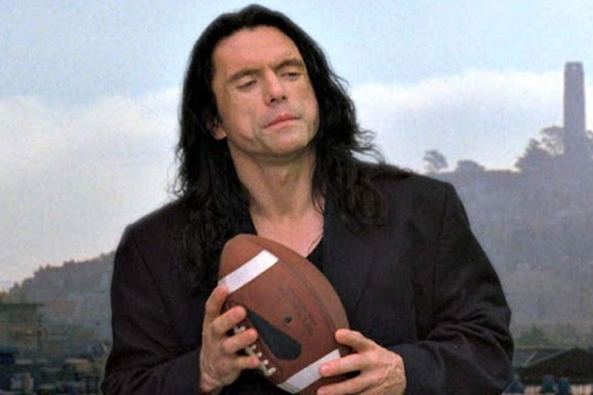 Tommy Wiseau holds a football in a scene from The Room