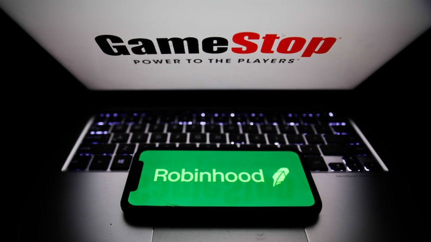 a mobile phone with the Robinhood logo on a laptop with the GameStop logo