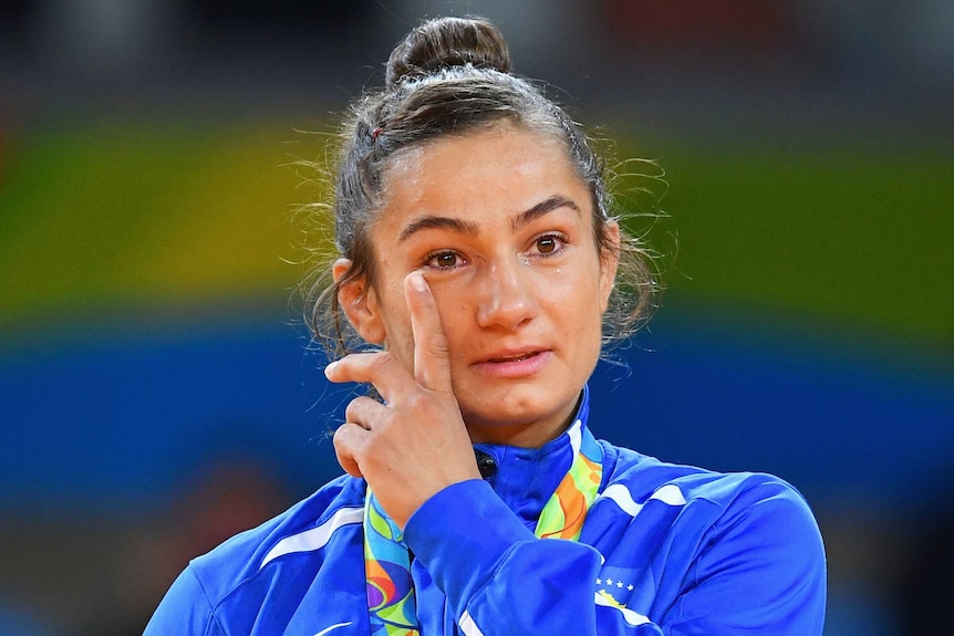 Gold medalist Majlinda Kelmendi wipes away a tear during the medal ceremony.