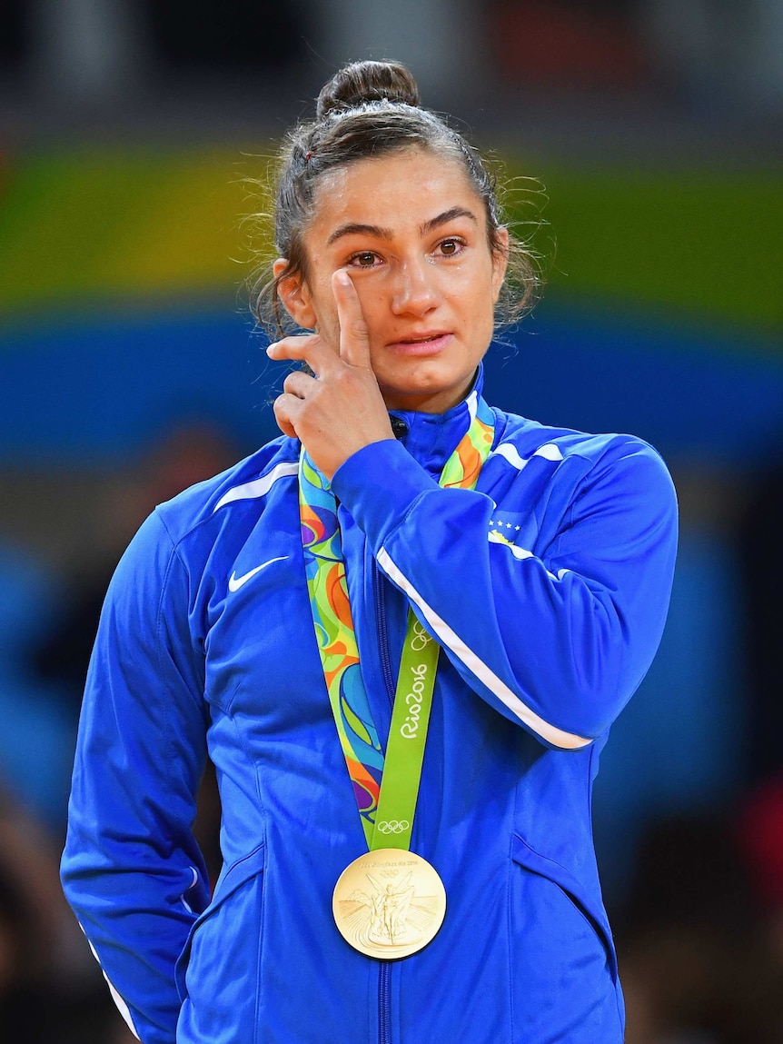 Gold medalist Majlinda Kelmendi wipes away a tear during the medal ceremony.