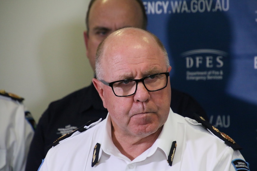 Headshot of a man in uniform wearing glasses and epaulettes