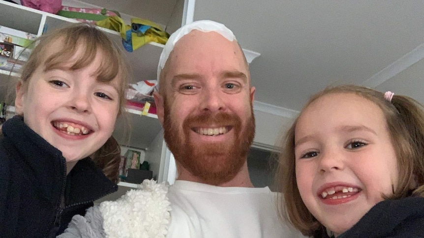 Todd Murfitt in hospital with his two children.