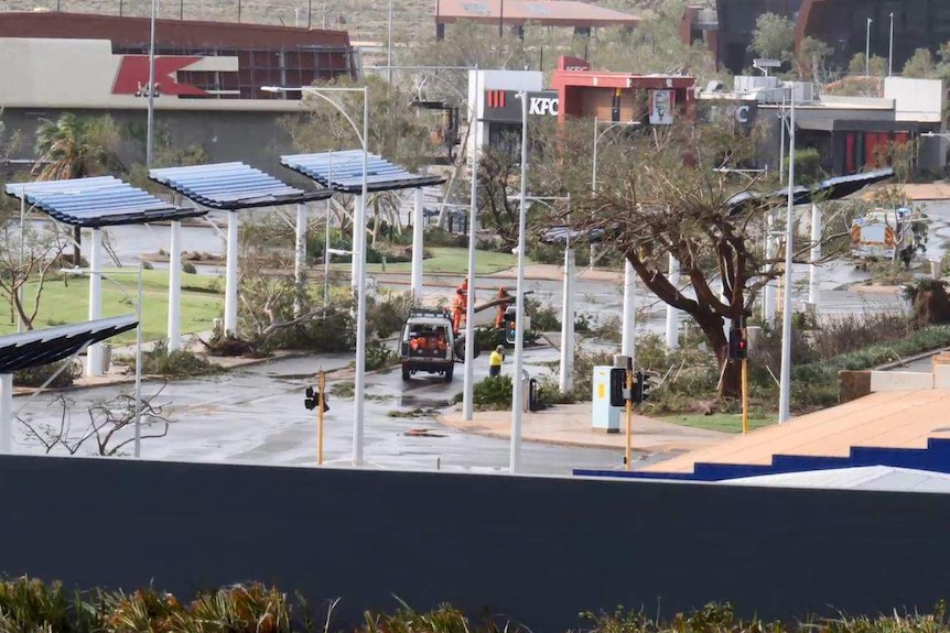 Trees are down all over the road and people in bright fluoro SES gear work to clear it.