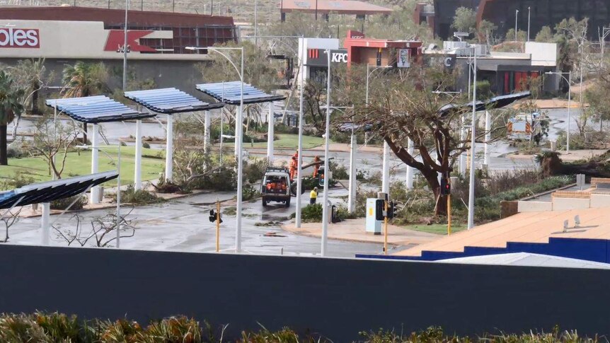 Trees are down all over the road and people in bright fluoro SES gear work to clear it.