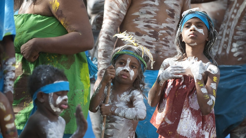 Young Indigenous person dressed in paint, feathers