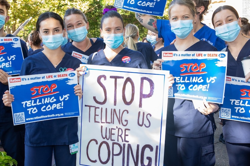 a group of young female nurses holding signs that read stop telling us to cope