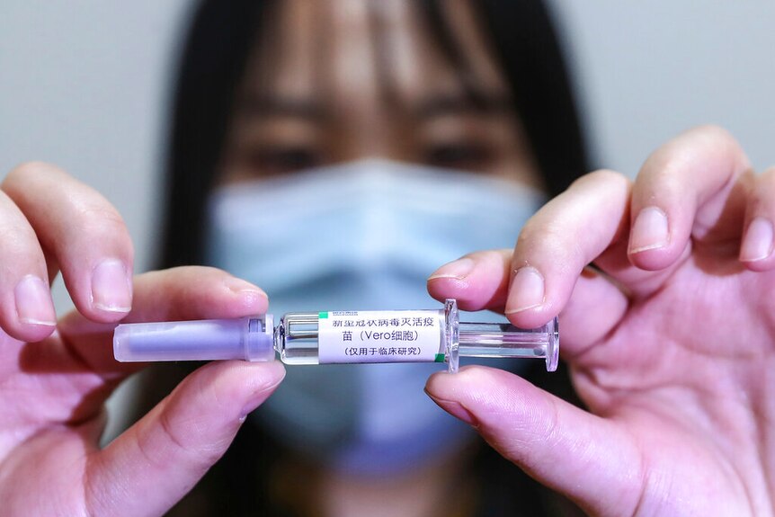A Chinese woman holding a vaccine in clinical trial