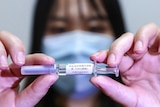 A Chinese woman holding a vaccine in clinical trial