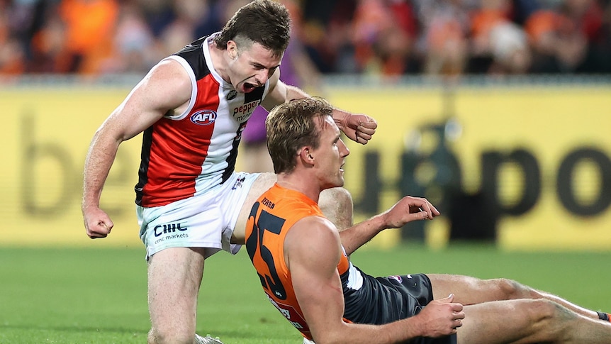 Jack Higgins kneels over Lachie Keeffe and yells in his direction