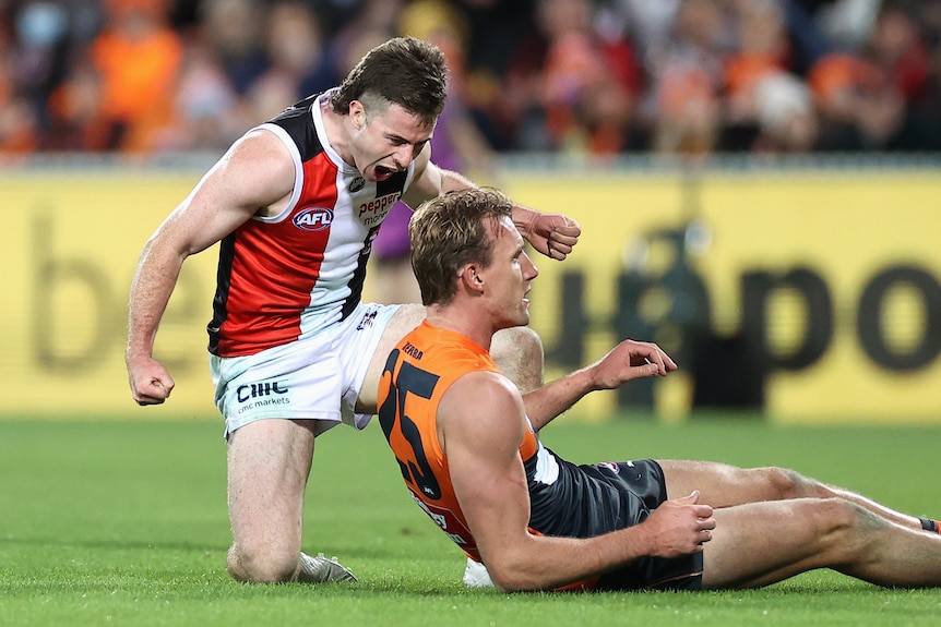 Jack Higgins kneels over Lachie Keeffe and yells in his direction