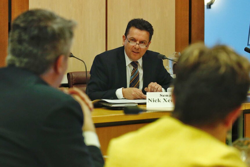 South Australian senator Nick Xenophon talks to colleagues during Senate Estimates.