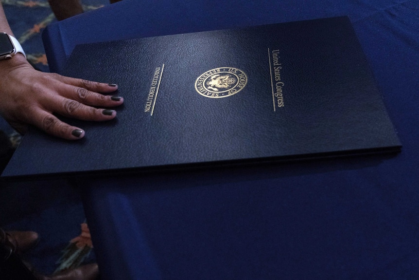A dark blue folder with the US Congress crest on it.