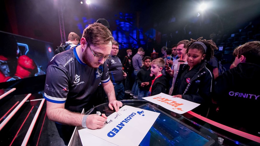 Gfinity esports gamers sign autographs at an event in the UK