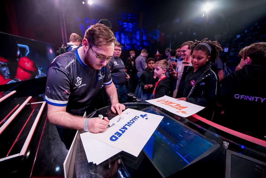 Gfinity esports gamers sign autographs at an event in the UK