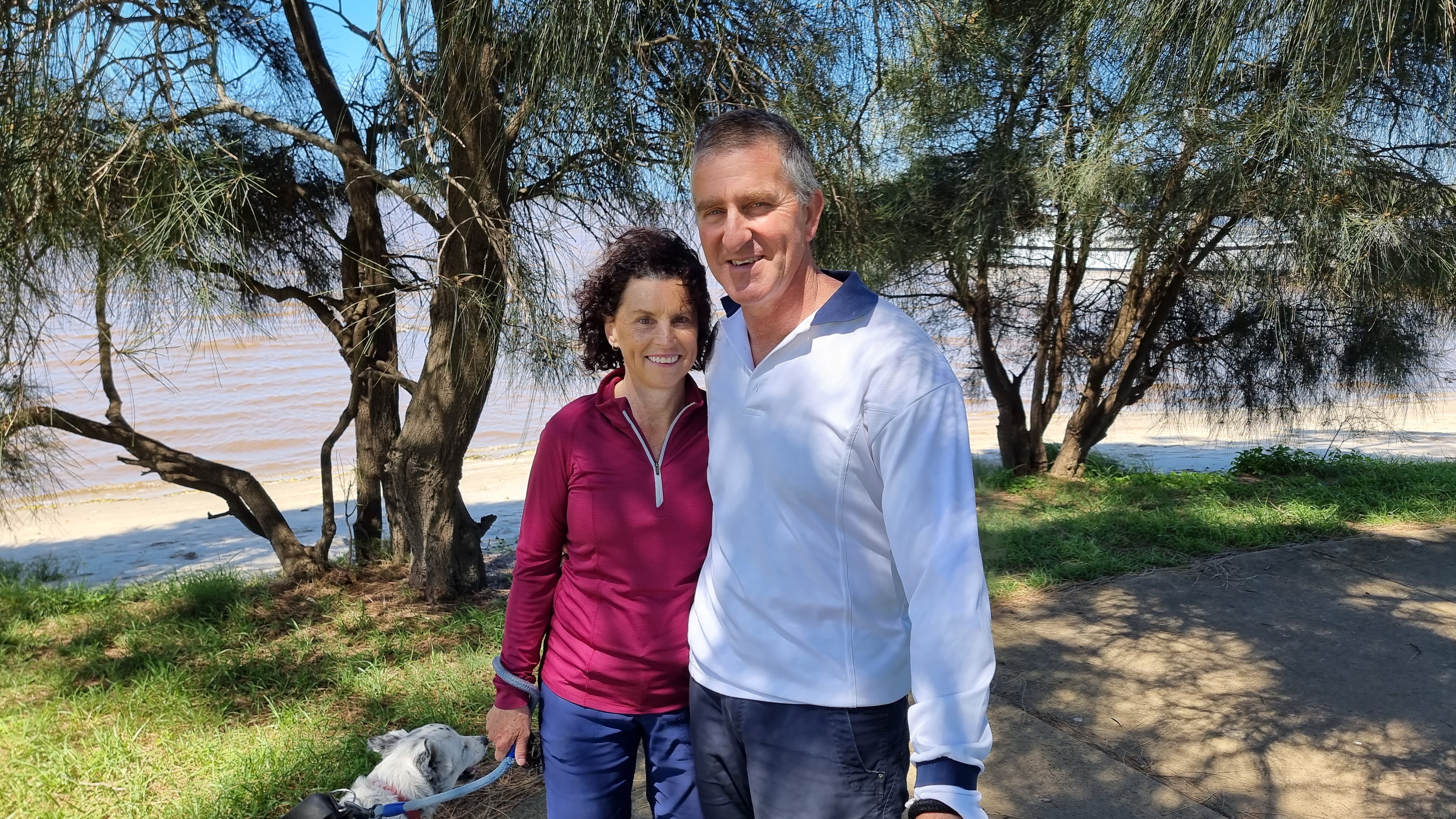 A woman and man stand next to each other smiling.