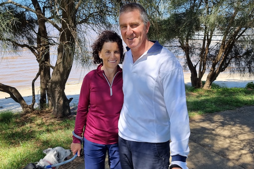 A woman and man stand next to each other smiling.