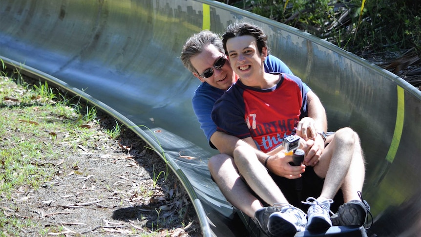 A father and son ride a toboggan together