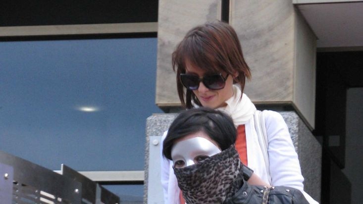 Hobart woman Jazmin Iris Haygarth leaves Magistrates Court with a masked friend.