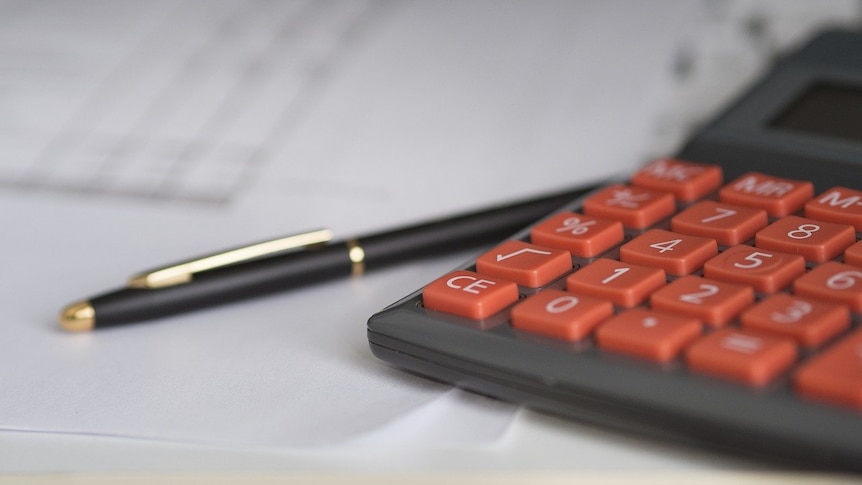 Calculator and pen on sheets of paper.