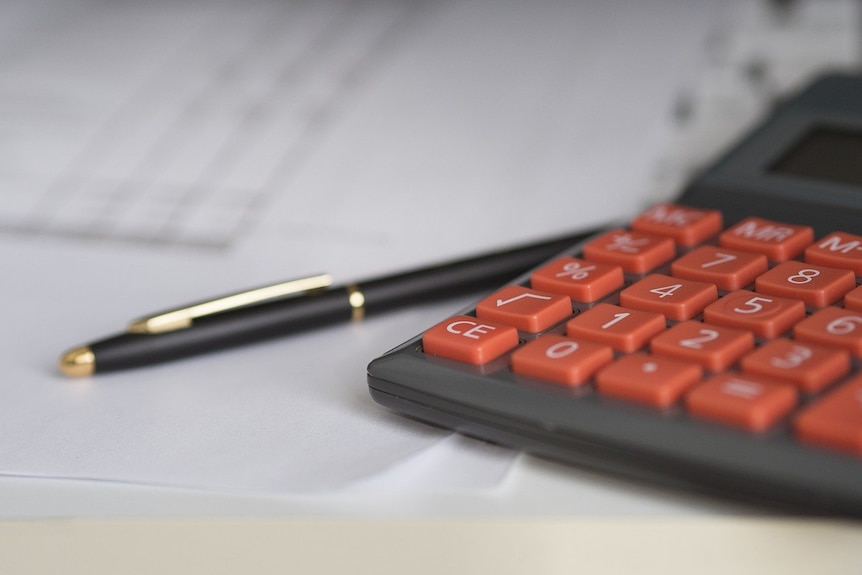 Calculator and pen on sheets of paper.