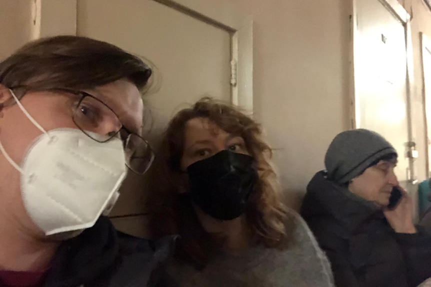Three people sitting in a Kyiv bomb shelter