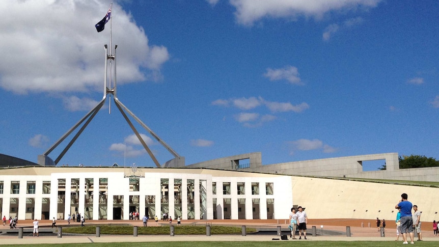 People take photos outside Parliament House