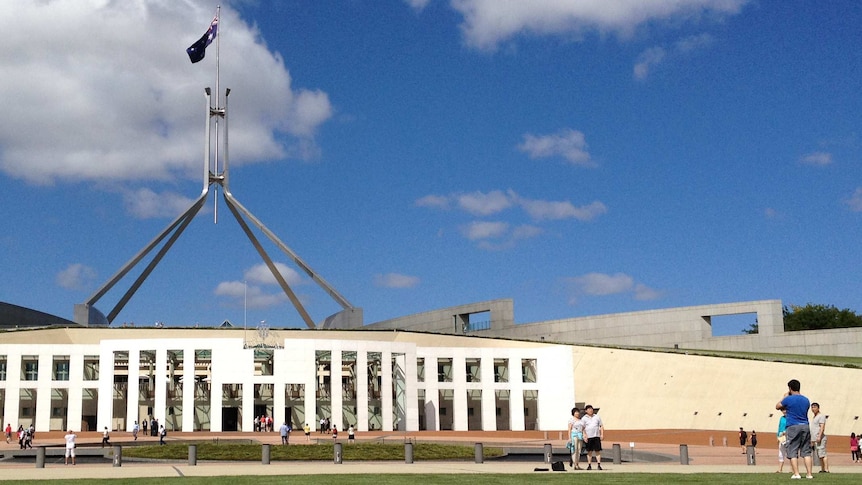 Tourists take photos outside Parliament House