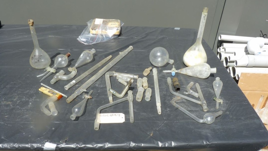 Glass pipes and drug paraphernalia laying on a black table