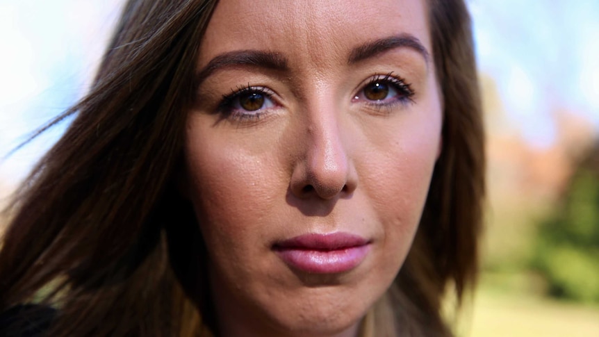 Portrait photo of woman with long brown hair and brown eyes looking at camera.