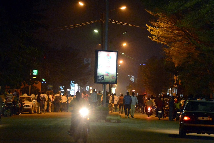 People gather near Ouagadougou's Hotel Splendid in Burkina Faso after a suspected terror attack.