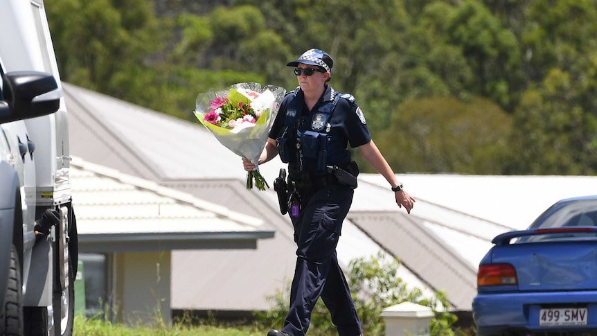 A police officer placed flowers, brought over by a neighbour, at Ms Bradford's home.