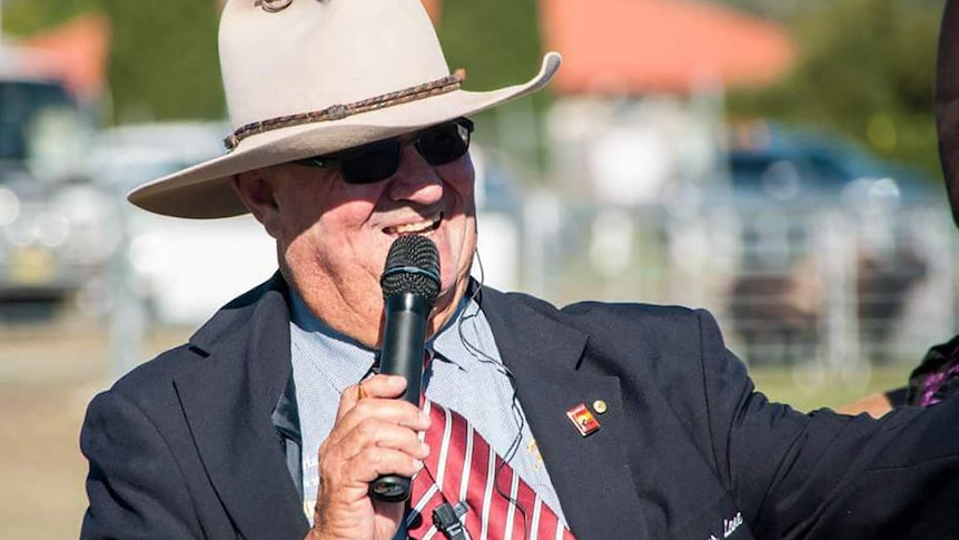 Close up of man in a big akubra holding a microphone to his lips