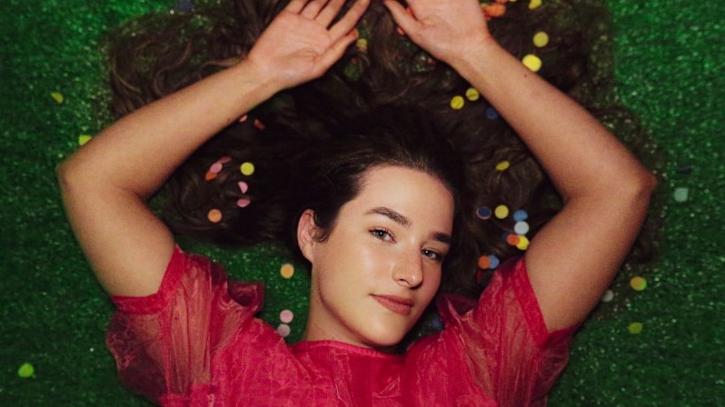 Mia Wray lies in the grass covered in confetti