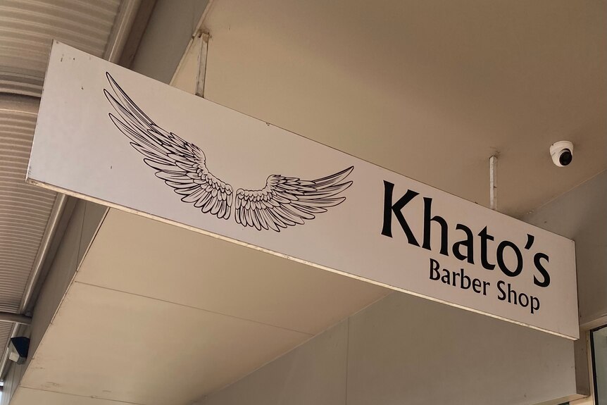 Board with khatos barbershop on it.