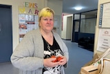 A photo of a woman holding tomatoes 