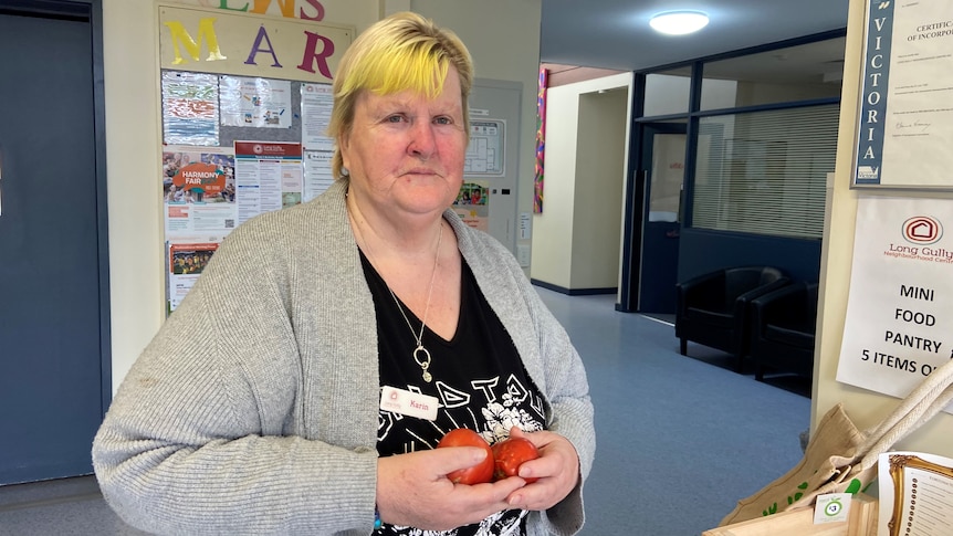 A photo of a woman holding tomatoes 