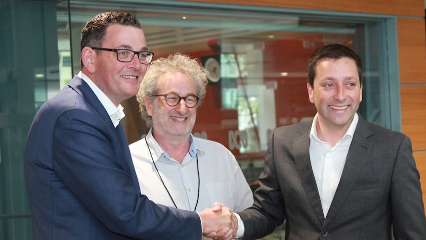 Victorian Premier Daniel Andrews, ABC Radio Melbourne host Jon Faine and Opposition Leader Matthew Guy outside a radio studio.