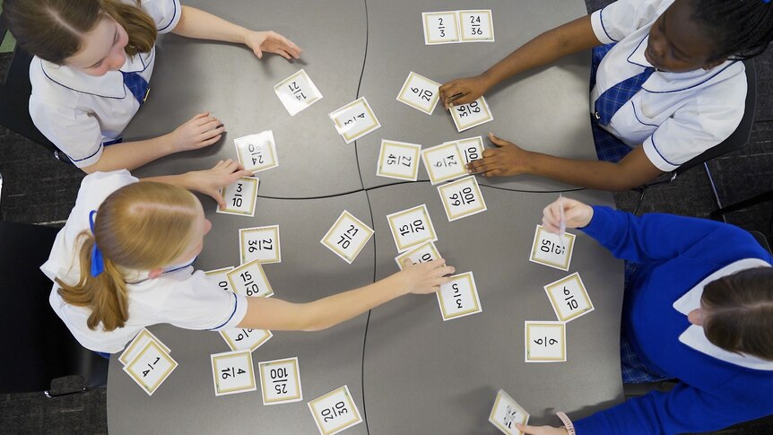 An image of students heads with spread out cards picturing fractions
